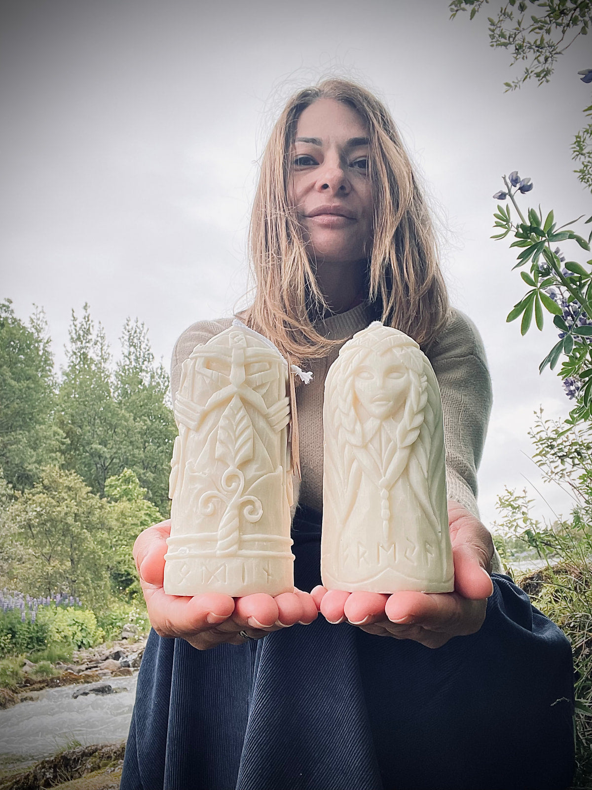 Woman holding Odin and Freyja carved ritual candles outdoors — Fyrda Candle eco gift set